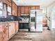 This kitchen has dark wood cabinets, stainless steel appliances, and an adjacent set of stairs at 712 Copper Trace Way, Woodstock, GA 30189
