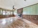 Spacious living room featuring a brick fireplace, wood paneling and a ceiling fan at 712 Copper Trace Way, Woodstock, GA 30189