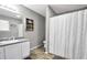 Well-lit bathroom with a single sink vanity and shower with modern curtain at 107 Gwenellen Dr, Locust Grove, GA 30248