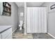 Well-lit bathroom features a vanity, toilet and shower, with neutral walls and floors at 107 Gwenellen Dr, Locust Grove, GA 30248