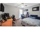 Spacious bedroom with desk, bed, ceiling fan and a large window at 107 Gwenellen Dr, Locust Grove, GA 30248