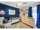 Charming Bedroom with crib, dresser, blue accent wall, and decorative touches at 107 Gwenellen Dr, Locust Grove, GA 30248