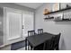 Cozy dining area with a black table and chairs, complemented by wall-mounted shelves at 107 Gwenellen Dr, Locust Grove, GA 30248
