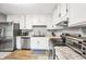 Bright kitchen featuring stainless steel appliances, granite countertops, and ample cabinet space at 107 Gwenellen Dr, Locust Grove, GA 30248
