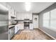 Bright kitchen features stainless steel appliances, white cabinets, and wood-look floors at 107 Gwenellen Dr, Locust Grove, GA 30248