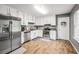Well-lit kitchen featuring modern stainless steel appliances, white cabinetry, and hardwood floors at 107 Gwenellen Dr, Locust Grove, GA 30248