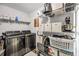Functional laundry room with a washer, dryer, and ample shelving for storage at 107 Gwenellen Dr, Locust Grove, GA 30248