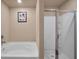 Clean bathroom featuring a soaking tub, a glass-enclosed shower, and neutral wall paint at 157 Oliver Dr, Locust Grove, GA 30248