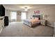 Spacious main bedroom with plush carpet, ceiling fan, and decorative touches at 157 Oliver Dr, Locust Grove, GA 30248