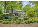 Landscaped backyard with lush greenery, grilling area and a charming two-story home at 173 Price Rd, Brooks, GA 30205