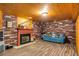 Cozy basement area with a brick fireplace, wood paneling, and comfortable seating at 173 Price Rd, Brooks, GA 30205
