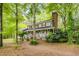 Charming two-story home with a inviting front porch, red shutters, and a mature tree-lined yard at 173 Price Rd, Brooks, GA 30205
