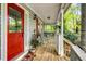 Charming front porch with a red door, rocking chairs, and decorative plants at 173 Price Rd, Brooks, GA 30205
