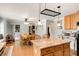 Open-concept kitchen with granite island, light wood cabinets, and view of dining area and backyard at 173 Price Rd, Brooks, GA 30205