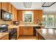 Bright kitchen featuring modern appliances, granite countertops, wooden cabinetry, and a charming window at 173 Price Rd, Brooks, GA 30205