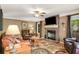 Cozy living room with a brick fireplace, plush leather furniture, and a ceiling fan at 173 Price Rd, Brooks, GA 30205