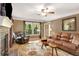 Inviting living room with hardwood floors, a brick fireplace, and comfortable leather seating at 173 Price Rd, Brooks, GA 30205