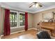 Inviting office space featuring hardwood floors, large windows with red curtains, and a classic piano at 173 Price Rd, Brooks, GA 30205