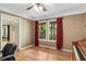 Bright office space featuring hardwood floors, large windows with red curtains, and a classic piano at 173 Price Rd, Brooks, GA 30205