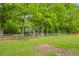 A sprawling green lawn and split rail fence surround a two-story home nestled among mature trees at 173 Price Rd, Brooks, GA 30205