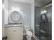 Bathroom with a stone countertop vanity, circular mirrors, and a glass-enclosed shower at 2548 Kickerillo Se Way, Atlanta, GA 30316