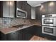 Stylish kitchen featuring dark wood cabinets, granite counters, and modern stainless steel appliances at 2548 Kickerillo Se Way, Atlanta, GA 30316