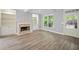 Bright living room with wood floors, a decorative fireplace, built-in shelving, and large windows that brighten the room at 2548 Kickerillo Se Way, Atlanta, GA 30316