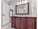 Bathroom with dark wood vanity, granite countertop, and decorative framed mirror at 5090 Eubanks Rd, Woodstock, GA 30188