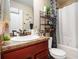 Bathroom featuring a sink, red cabinets, toilet, shower, and decor at 108 Telfair Ln, Mcdonough, GA 30253