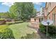 Spacious backyard with well-maintained landscaping, a stone fireplace, and a home visible in the background at 2652 Brickell Sq, Atlanta, GA 30341