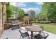 Relaxing backyard with a brick patio, outdoor fireplace, grill, table with chairs, and manicured landscaping at 2652 Brickell Sq, Atlanta, GA 30341