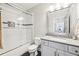 Clean bathroom featuring a shower-tub combo with sliding glass door, white cabinets and grey countertop at 2652 Brickell Sq, Atlanta, GA 30341
