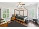 Cozy bedroom features a modern four poster bed, hardwood floors, natural light, and fresh decor at 2652 Brickell Sq, Atlanta, GA 30341