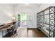 Bright office space with hardwood floors, a desk, shelves, and a door to a balcony overlooking the backyard at 2652 Brickell Sq, Atlanta, GA 30341