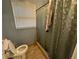 Cozy bathroom includes a toilet, shower with curtain, and window with blinds for natural light at 661 Oak Dr, Riverdale, GA 30274