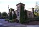 Community entrance featuring stone pillars, lush landscaping, and a decorative sign at 91 Batten Board Way, Woodstock, GA 30189