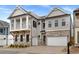 Gorgeous two-story home with stone and siding exterior, a two-car garage, and a quaint second story balcony at 91 Batten Board Way, Woodstock, GA 30189