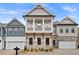 Attractive two-story home featuring stone accents, a two-car garage, and a charming second-story balcony at 91 Batten Board Way, Woodstock, GA 30189
