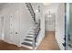 Bright foyer featuring hardwood floors, a staircase with iron railings, and elegant lighting fixtures at 91 Batten Board Way, Woodstock, GA 30189