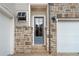 Close-up of the home's front door, showcasing the stone facade and stylish exterior lighting at 91 Batten Board Way, Woodstock, GA 30189