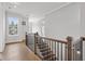Bright hallway with hardwood floors, wood and iron banister, and natural light from the window at 91 Batten Board Way, Woodstock, GA 30189