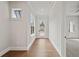 Bright hallway with hardwood floors, transom windows, and views into adjacent rooms at 91 Batten Board Way, Woodstock, GA 30189