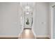 Well-lit hallway featuring hardwood floors, neutral walls, white trim, and elegant lighting fixtures at 91 Batten Board Way, Woodstock, GA 30189