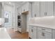 Bright kitchen featuring white cabinets, stainless steel appliances, and hardwood flooring at 91 Batten Board Way, Woodstock, GA 30189