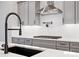 Kitchen features stainless steel hood, gas range, pull down faucet, and quartz counters at 91 Batten Board Way, Woodstock, GA 30189