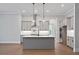 Island kitchen featuring gray cabinets, stainless hood, double oven, and hardwood floors at 91 Batten Board Way, Woodstock, GA 30189