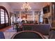 Open-concept living room features stone floors, chandelier, columns, stone fireplace, and an open kitchen at 91 Batten Board Way, Woodstock, GA 30189