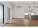 Open-concept room with hardwood floors, stylish chandelier, and sliding glass doors at 91 Batten Board Way, Woodstock, GA 30189
