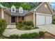 Charming home with two-car garage, manicured front yard, and welcoming entryway with black door at 1909 Riverlanding Cir, Lawrenceville, GA 30046