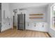Spacious kitchen boasts stainless steel fridge, stylish cabinets and counters, plus functional floating shelves at 1909 Riverlanding Cir, Lawrenceville, GA 30046